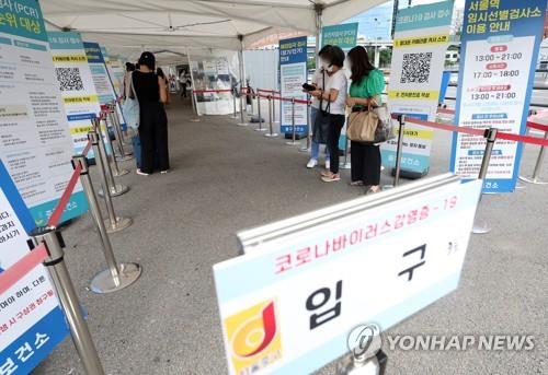 Las personas esperan en fila para someterse a las pruebas del COVID-19, el 18 de septiembre de 2022, en una clínica provisional, en el centro de Seúl.