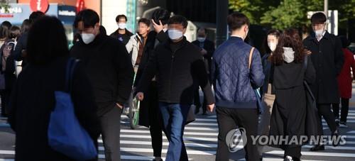 Los peatones caminan vistiendo abrigos, el 18 de octubre de 2022, en una calle del centro de Seúl.
