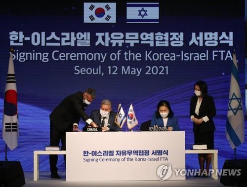 La foto de archivo, tomada el 12 de mayo de 2021, muestra a la entonces jefa negociadora de comercio surcoreano, Yoo Myung-hee (2ª por la dcha.), y su homólogo israelí, Amir Peretz (2º por la izda.), participando en la ceremonia de firma del TLC de sus países, en Seúl.