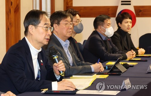El primer ministro, Han Duck-soo (izda.), habla durante una reunión con altos funcionarios de la oficina presidencial y el gobernante Partido del Poder del Pueblo, celebrada, el 8 de enero de 2023, en la Asamblea Nacional, en Seúl.