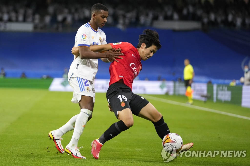In this Associated Press photo, Lee Kang-in of RCD Mallorca (R) and Rodrygo of Real Madrid battle for the ball during their La Liga match at Santiago Bernabeu Stadium in Madrid on Sept. 22, 2021. (Yonhap)