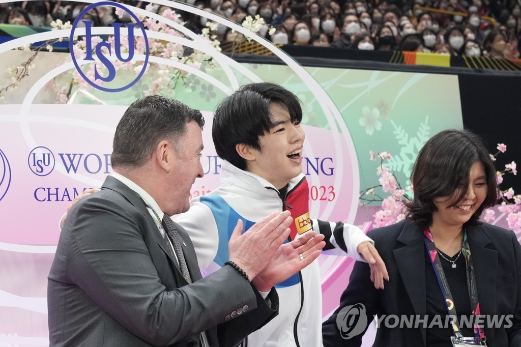 In this Associated Press photo, Cha Jun-hwan of South Korea (C) celebrates with his coaches, Brian Orser (L) and Chi Hyun-jung, after finishing his free skate in the men's singles competition at the International Skating Union World Figure Skating Championships at Saitama Super Arena in Saitama, Japan, on March 25, 2023. (Yonhap)