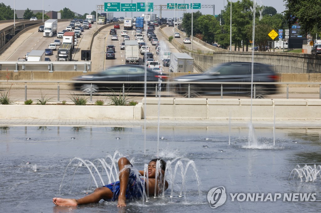 미국 텍사스 댈러스의 한 분수에서 무더위 식히는 소년