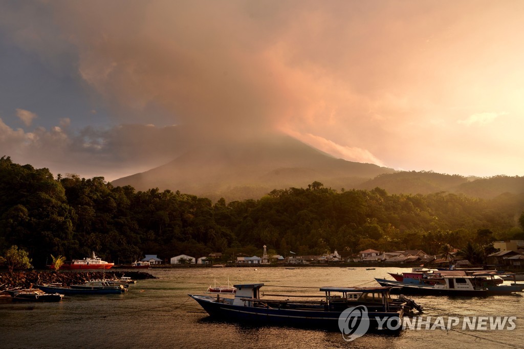 2019년 2월 7일 인도네시아 북술라웨시 주 시아우 섬 페헤 항에서 바라 본 카랑에탕 화산. 정상에서 화산재 섞인 연기가 뿜어져 나오고 있다. [AFP=연합뉴스]