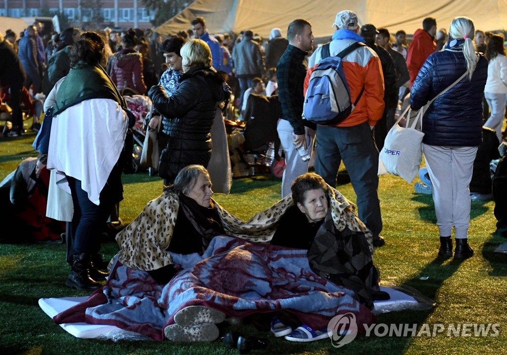 규모 6.4의 강진으로 건물이 무너지자 대피한 주민들이 축구경기장에 모여있다. 