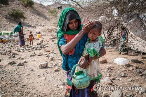 지난 6월 아이의 얼굴을 씻기는 한 에티오피아 난민 여성