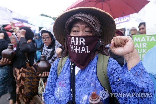 2017년 3월 22일 인도네시아 자카르타에서 열린 '세계 물의 날' 행사에 '물이 비싸다'는 글이 적힌 마스크를 주민이 참석해 시위를 벌이고 있다. [EPA=연합뉴스]