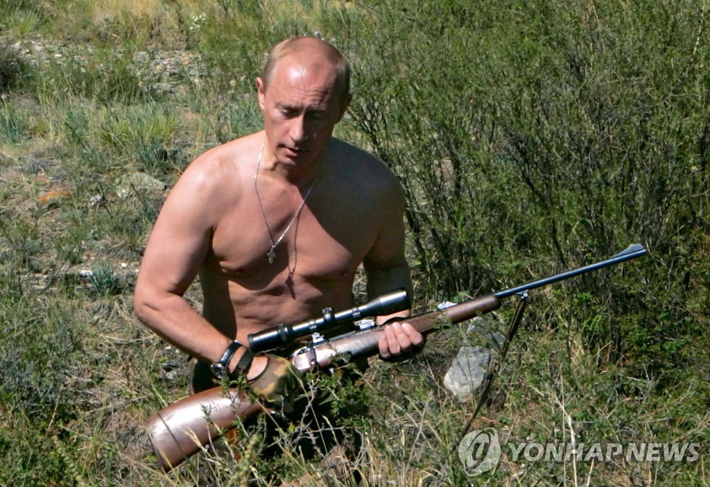 상의를 벗고 총을 든 채 '강인한 남성' 이미지를 과시하는 푸틴 대통령 