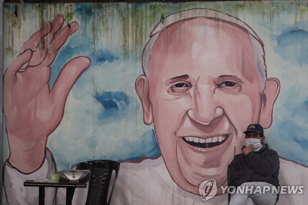교황 벽화 근처 앉아있는 아르헨티나 노숙자