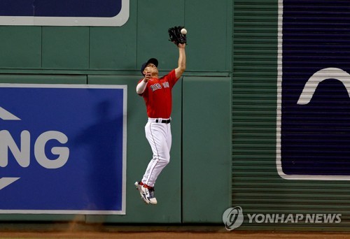 In this Getty Images file photo from June 14, 2022, Rob Refsnyder of the Boston Red Sox makes a catch at the wall during the top of the sixth inning of a Major League Baseball regular season game at Fenway Park in Boston. (Yonhap)