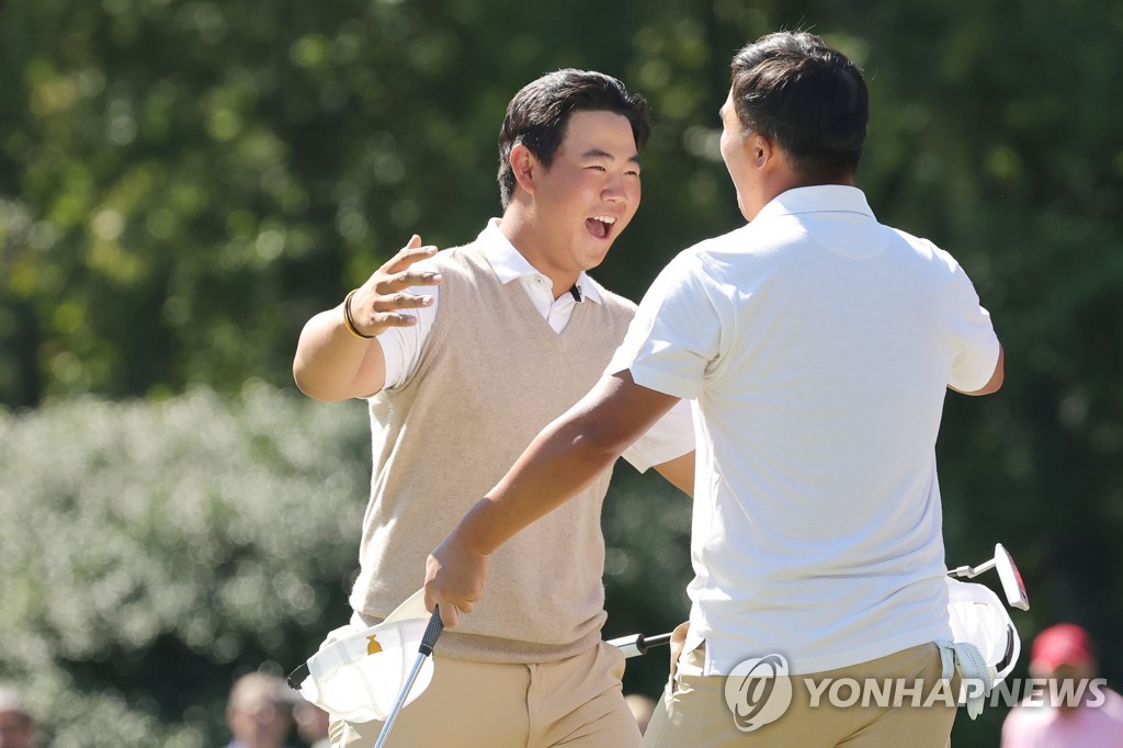 In this Getty Images photo, South Koreans Kim Joo-hyung (L) and Lee Kyoung-hoon of the International Team celebrate their foursome victory over Scottie Scheffler and Sam Burns of the United States at the Presidents Cup at Quail Hollow Club in Charlotte, North Carolina, on Sept. 24, 2022. (Yonhap)