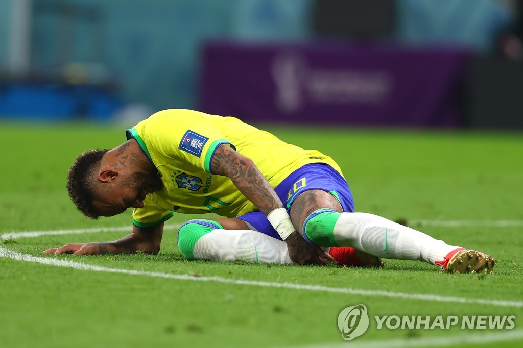 In this UPI photo, Neymar of Brazil grabs his injured right ankle during Brazil's Group G match against Serbia at the FIFA World Cup at Lusail Stadium in Lusail, north of Doha, on Nov. 24, 2022. (Yonhap)
