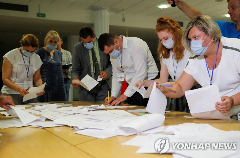 (로이터=연합뉴스) 벨라루스 선관위 위원들이 9일(현지시간) 대선 투표 종료 후 개표하는 모습. 