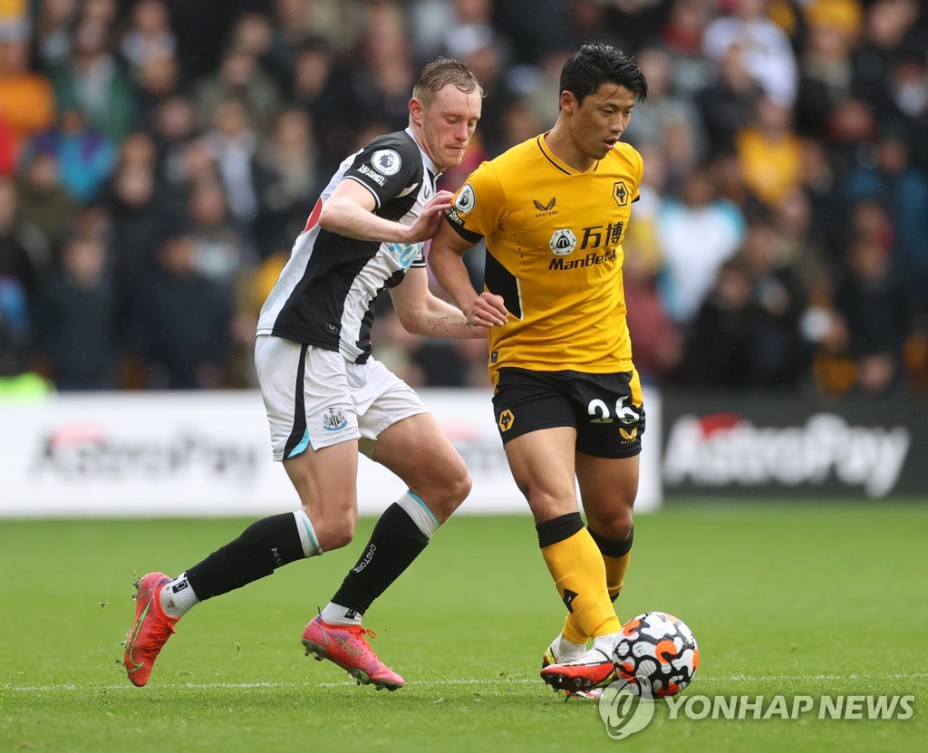 In this Reuters photo, Hwang Hee-chan of Wolverhampton Wanderers (R) tries to hold off Sean Longstaff of Newcastle United during the clubs' Premier League match at Molineux Stadium in Wolverhampton, England, on Oct. 2, 2021. (Yonhap)