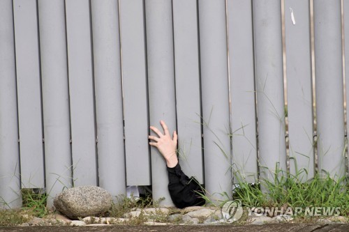 멕시코 치아파스 이민청 건물 밖으로 손 내민 극단주의 종교신자의 손