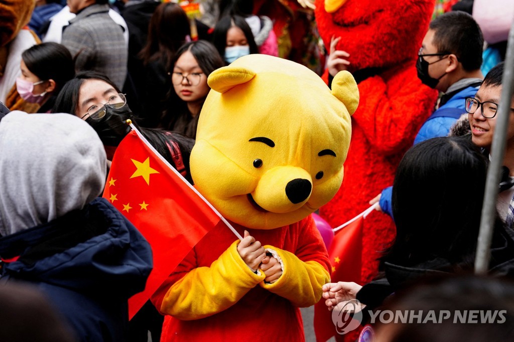 (로이터=연합뉴스) 지난달 12일 미국 뉴욕의 음력설 축하 퍼레이드에서 곰돌이 푸 의상을 입은 참가자가 중국 국기를 흔드는 모습. 2023.3.21. 