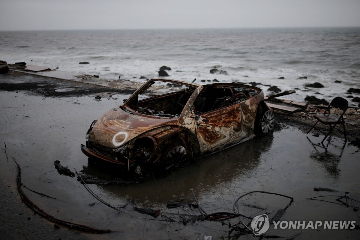 산불에 탄 차량이 폭우로 바닷가에 떠내려온 모습 