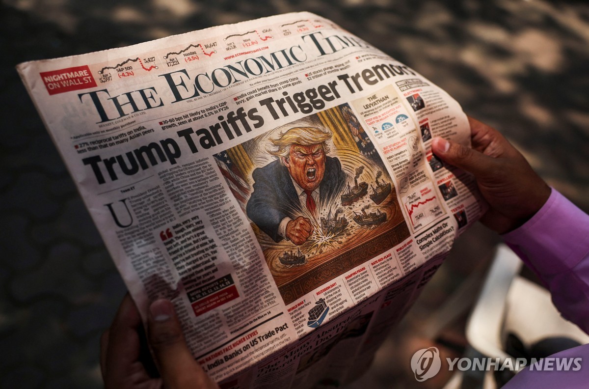 트럼프 관세 정책 관련 신문 기사 읽는 인도 주민