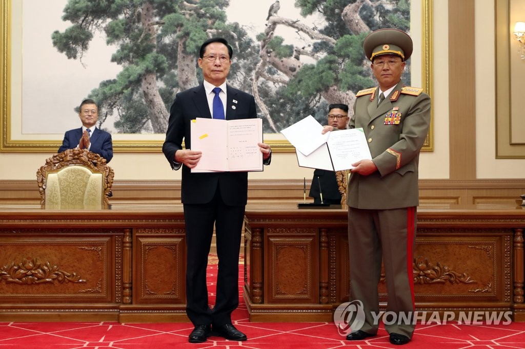 This file photo, taken Sept. 19, 2018, shows then Defense Minister Song Young-moo (2nd from L) and his North Korean counterpart, No Kwang-chol, posing for a photo after signing the Comprehensive Military Agreement at the Baekhwawon state guesthouse in Pyongyang. Then President Moon Jae-in (L) and North Korean leader Kim Jong-un (2nd from R) are seen in the back. (Pool photo) (Yonhap)