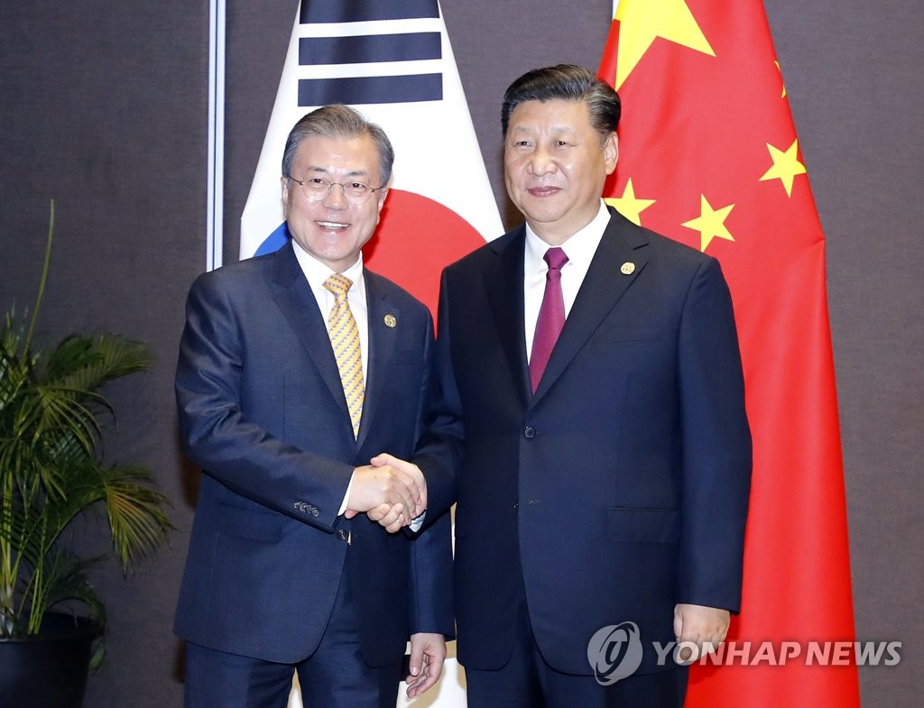 South Korean President Moon Jae-in (L) shakes hands with Chinese President Xi Jinping before their talks in Papua New Guinea on the sidelines of the Asia Pacific Economic Cooperation (APEC) forum on Nov. 17, 2018. (Yonhap)