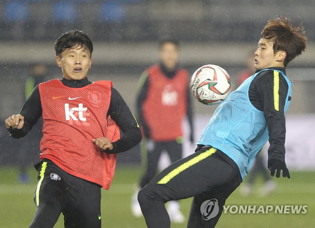 South Korea national football team left back Kim Jin-su (R) controls the ball against forward Cho Young-wook during training at Ulsan Stadium in Ulsan on Dec. 11, 2018. (Yonhap)