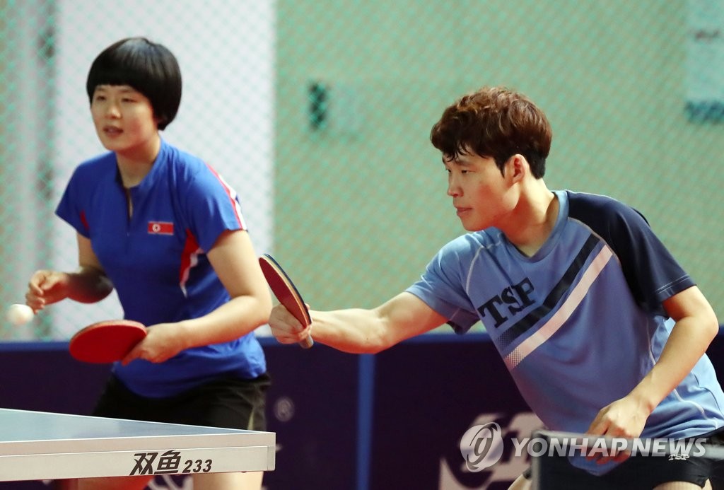 Cha Hyo-sim of North Korea (L) and Jang Woo-jin of South Korea practice together on Dec. 12, 2018, ahead of their mixed doubles competition at the International Table Tennis Federation World Tour Grand Finals at Namdong Gymnasium in Incheon, 40 kilometers west of Seoul. (Yonhap)