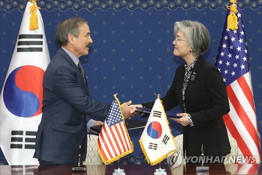 In this file photo, taken on March 8, 2019, South Korean Foreign Minister Kang Kyung-wha (R) shakes hands with U.S. Ambassador to South Korea Harry Harris during a ceremony at the foreign ministry in Seoul to sign the Special Measures Agreement, a cost-sharing contract. The new deal calls for an 8.2 percent increase in Seoul's contribution to some 1.04 trillion won over a year. (Yonhap)