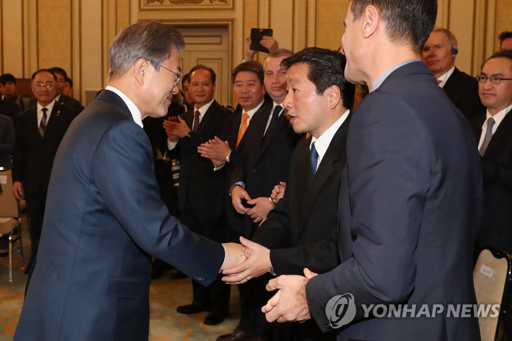 懇談会で森山氏と握手を交わす文大統領（左）＝２８日、ソウル（聯合ニュース）