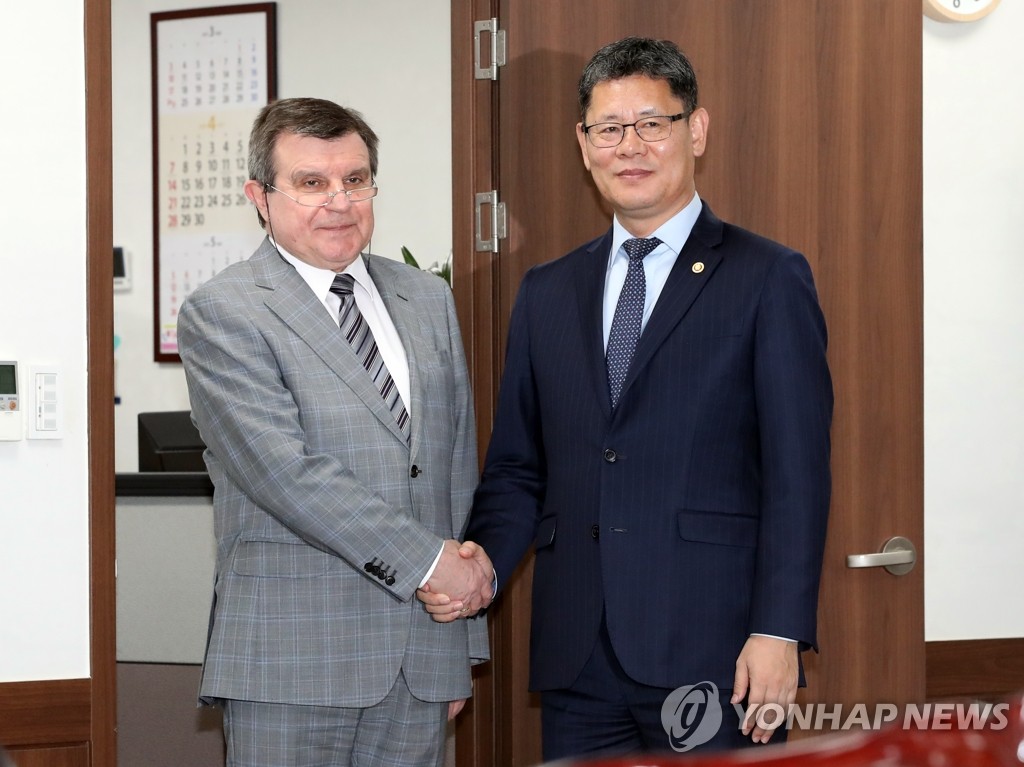 Unification Minister Kim Yeon-chul (R) poses for a photo with Russian Ambassador to South Korea Andrey Kulik during a meeting at the government complex in Seoul on April 22, 2019. (Yonhap)