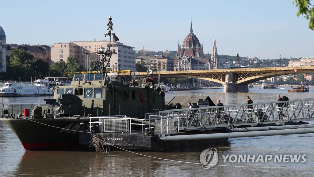 Hungarian rescue workers move equipment onto a military ship in apparent preparation for underwater search operations on the Danube River in Budapest on June 3, 2019. (Yonhap) 