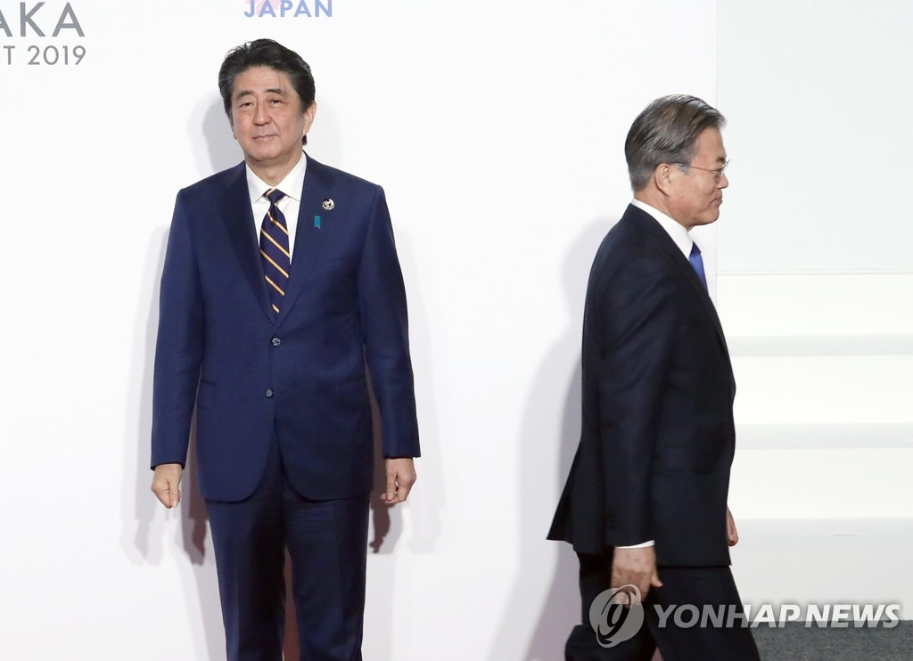 문재인 대통령이 2019년 6월 28일 당시 일본 인텍스 오사카에서 열린 G20 정상회의 공식환영식에서 의장국인 아베 신조 일본 총리와 악수한 뒤 이동하고 있다. [연합뉴스 자료사진]