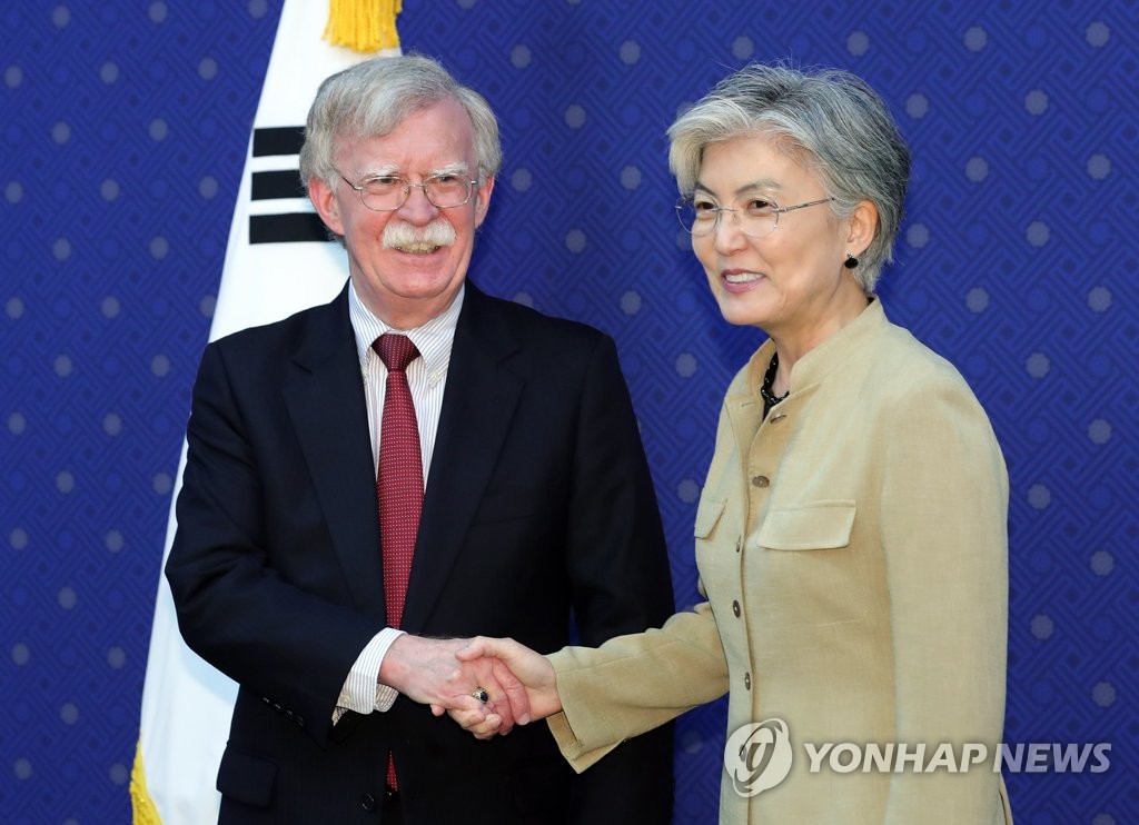 In the file photo, taken July 24, 2019, John Bolton (L), former national security adviser to U.S. President Donald Trump, is seen shaking hands with South Korean Foreign Minister Kang Kyung-wha during his visit to the South Korean Foreign Ministry in Seoul. (Yonhap)