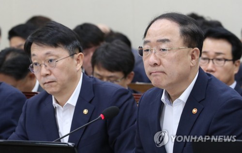 全体会議に出席した洪楠基（ホン・ナムギ）経済副首相兼企画財政部長官（右）＝２２日、ソウル（聯合ニュース）