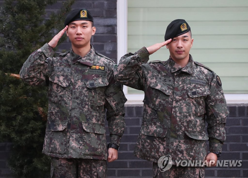 资料图片：2019年11月10日，在京畿道龙仁市地面作战司令部前，BIGBANG成员太阳（右）和大成敬军礼。当天，二人正式退伍。 韩联社