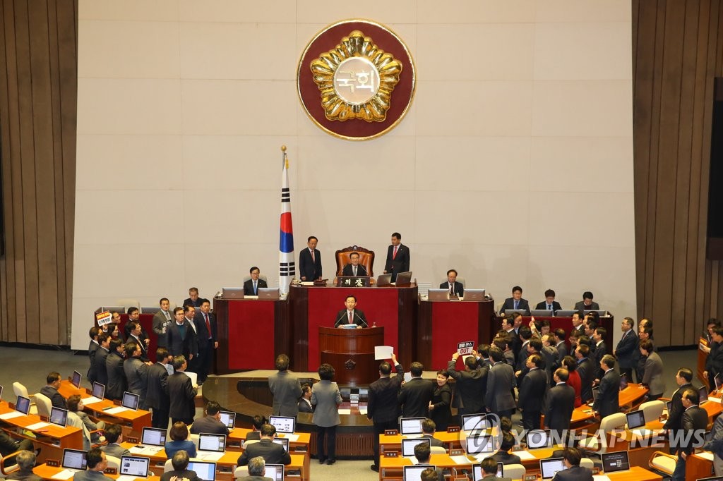 Lawmakers from South Korea's main opposition Liberty Korea Party protest as Speaker Moon Hee-sang (C, behind podium) presides over a plenary session to deal with contentious bills to revise electoral rules and overhaul the prosecution at the main chamber of the National Assembly in Seoul on Dec. 23, 2019. (Yonhap)