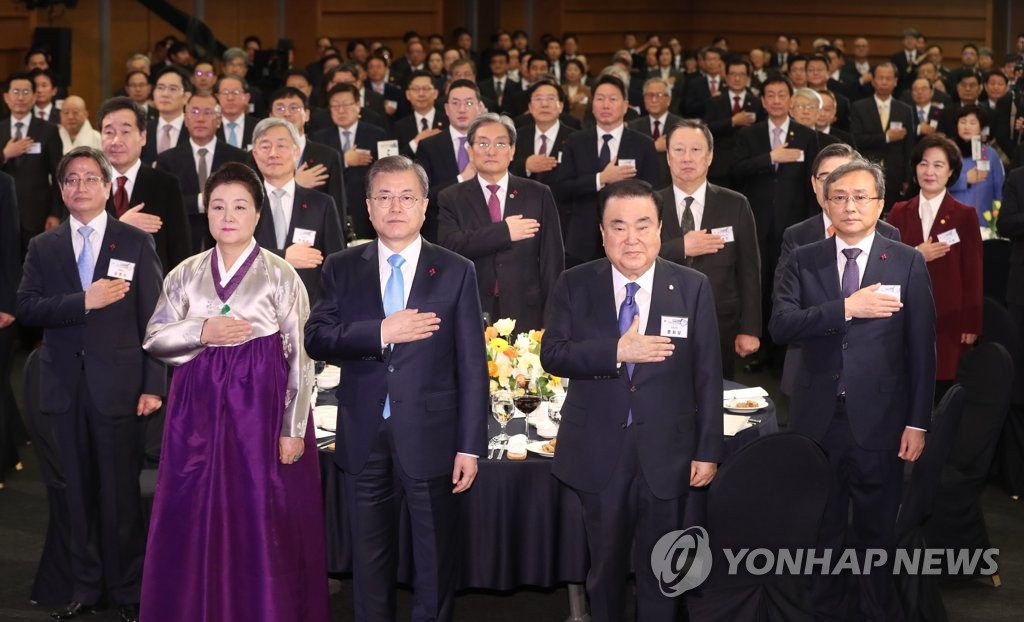 新年会で国旗に敬礼する文大統領（手前中央）＝２日、ソウル（聯合ニュース）