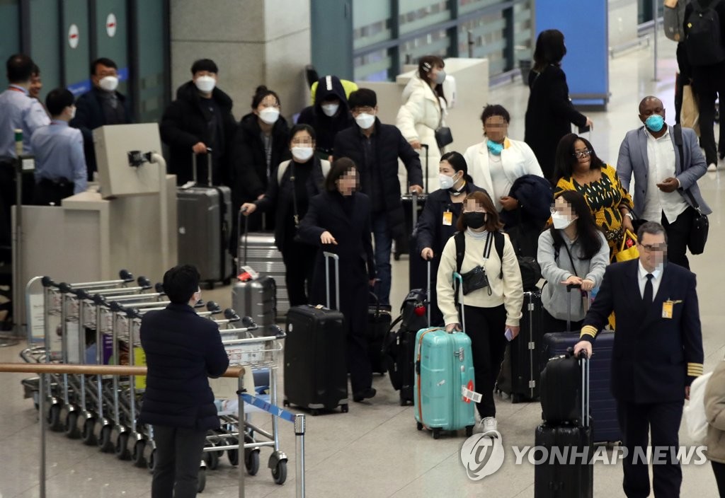 仁川国際空港からマスク姿で入国する人々＝３日、仁川（聯合ニュース）