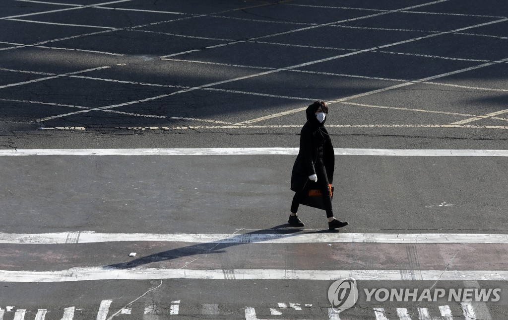 인적 끊긴 교차로 건너는 이란 여성