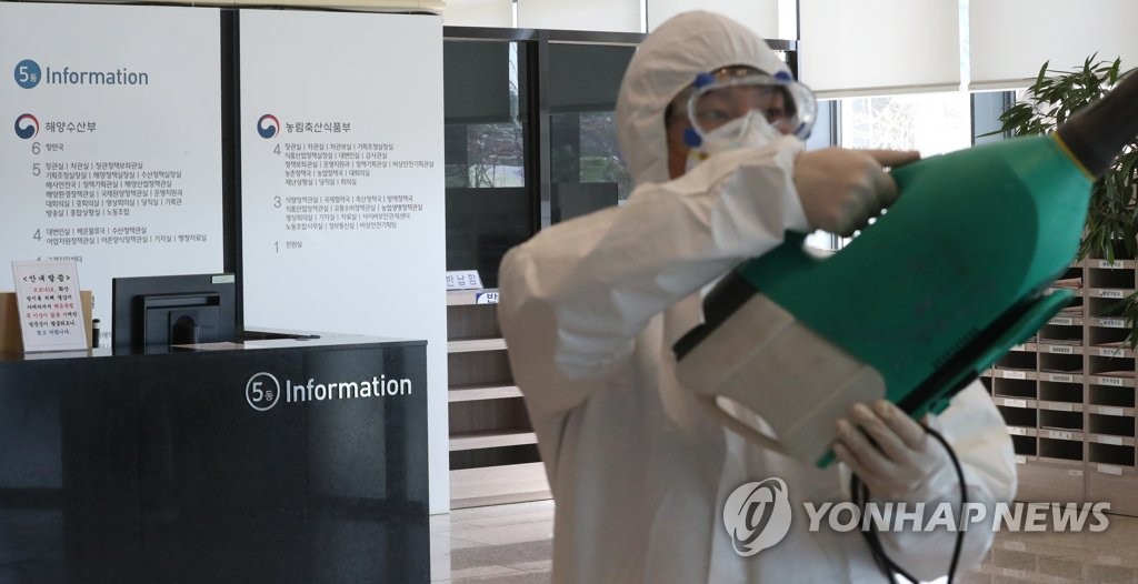 A quarantine official carries out a disinfection operation at the Sejong government complex in the administrative city of Sejong, 130 kilometers south of Seoul, on March 11, 2020. (Yonhap)