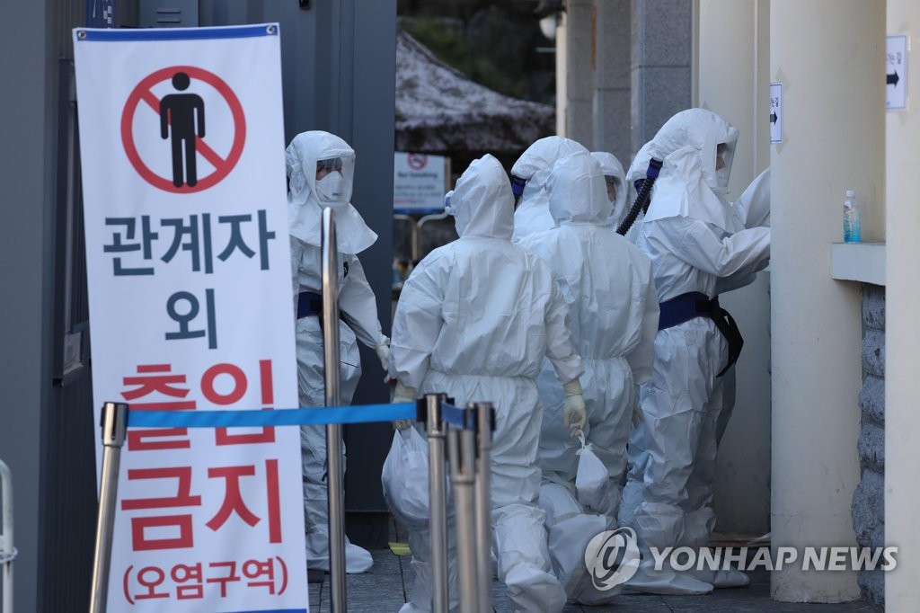 资料图片：医务人员走入新冠病例收治病房。 韩联社