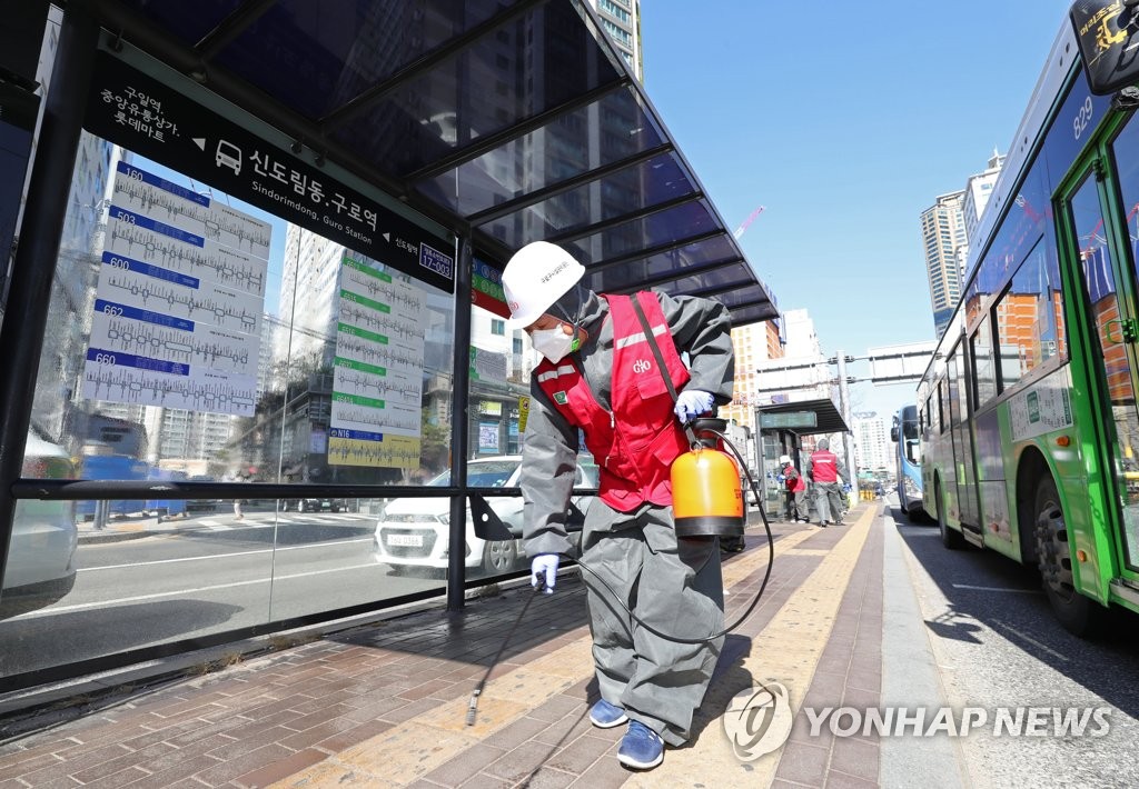 Officials disinfect a bus station in Guro Ward in Seoul on March 14, 2020. (Yonhap)