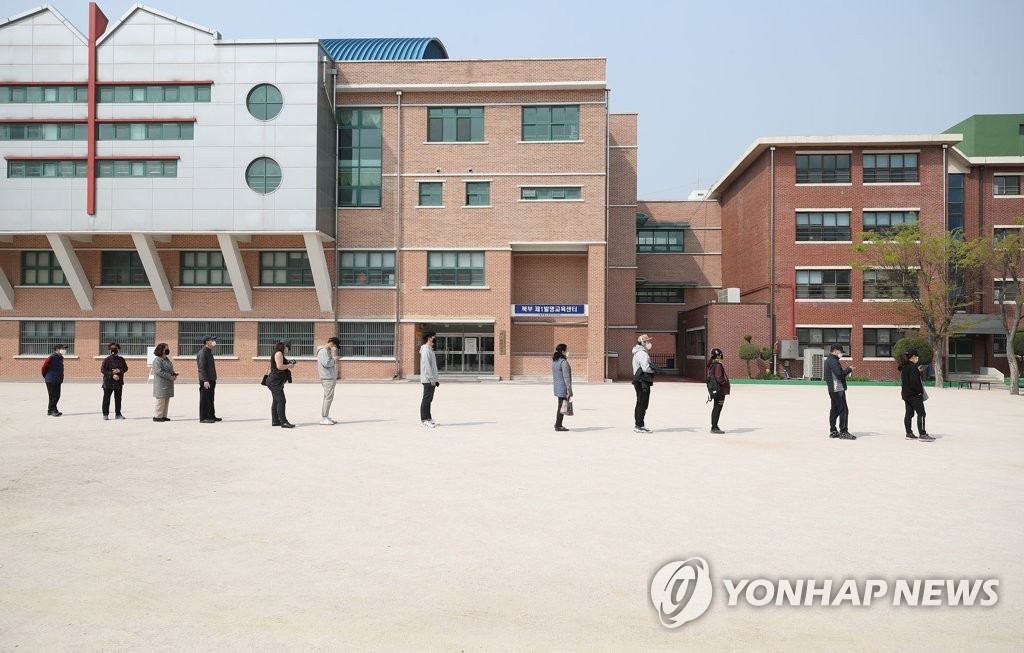 Voters form a line to cast their ballots at a polling station in Seoul on April 15, 2020, as South Koreans began voting the same day to elect a new parliament amid the outbreak of the new coronavirus. (Yonhap)
