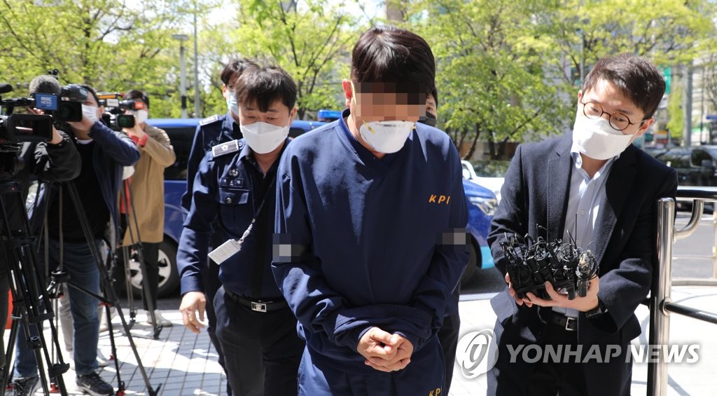 A former presidential official, surnamed Kim, is surrounded by reporters on April 18, 2020 at the Seoul Southern District Court where he attended a court hearing to decide whether to issue an arrest warrant over his role in a financial scandal involving Lime Asset Management Co. (Yonhap)
