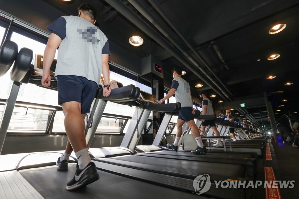 People exercise on treadmills at a gym in Seoul on April 21, 2020. (Yonhap)
