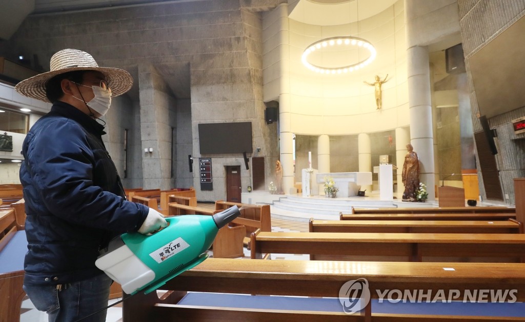 An official disinfects a cathedral in Seoul on April 22, 2020, one day before the Archdiocese of Seoul resumes Mass after an almost two-month suspension due to the spread of the new coronavirus. (Yonhap)