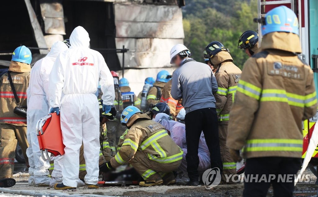 Fire fighters rescue an injured worker at the site of a fire that broke out at a warehouse construction site in Icheon, Gyeonggi Province, on April 29, 2020. (Yonhap)