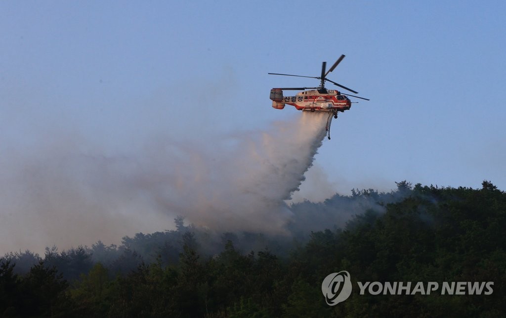 A firefighting helicopter carries out an operation to extinguish a forest fire in Goseong, some 160 kilometers northeast of Seoul, on May 2, 2020. The fire broke out a day earlier. (Yonhap)