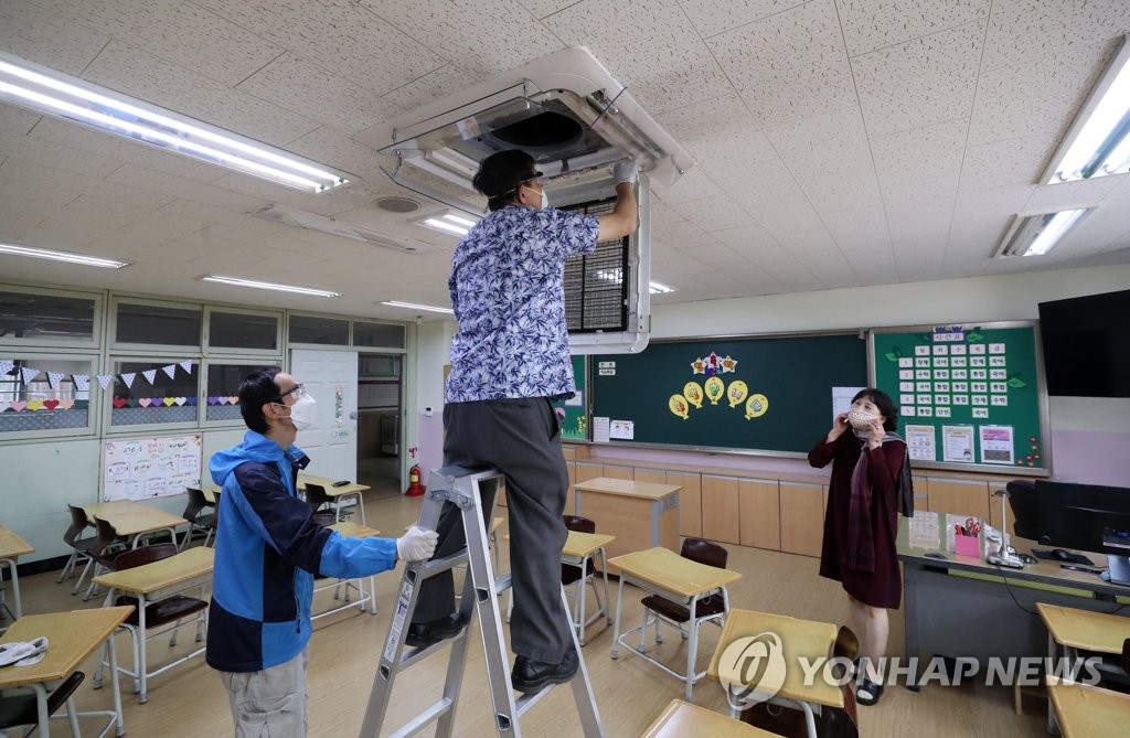登校開始を前に、ソウル市内の小学校でエアコンの清掃と点検を行っている（資料写真）＝（聯合ニュース）