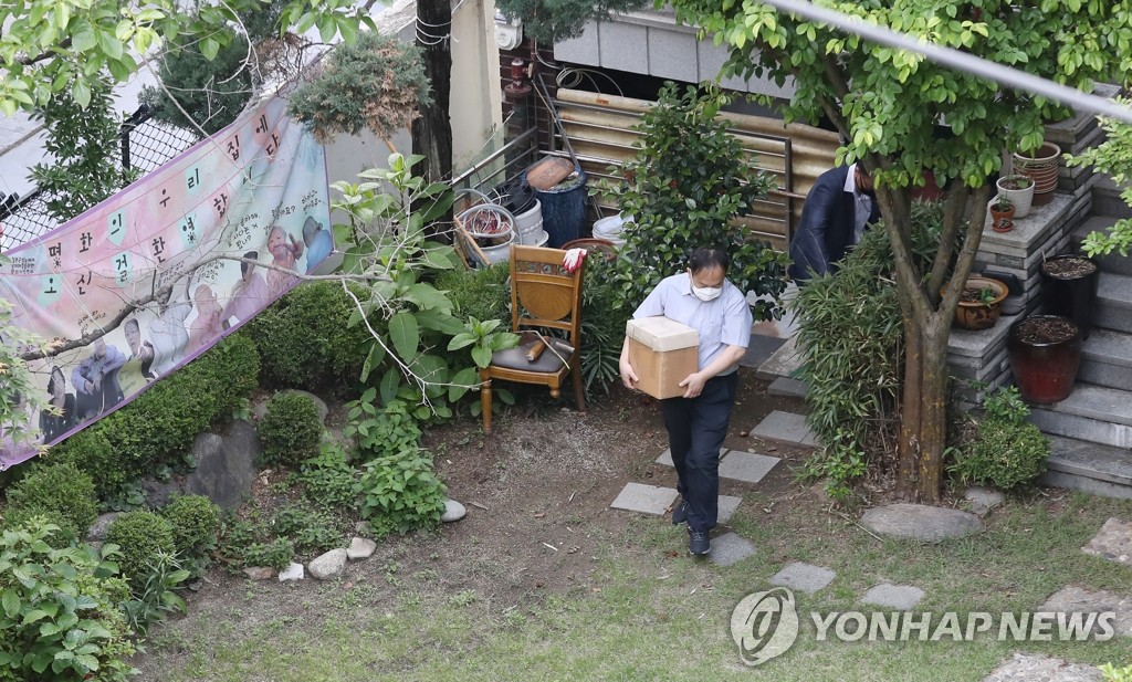 This file photo, from May 21, 2020, shows prosecutors carrying out evidence from a shelter in Mapo, western Seoul, run by the Korean Council for Justice and Remembrance, a NGO working for South Korea's 'comfort women, as part of an investigation over allegations that former chief of the group, Rep. Yoon Mee-hyang, misused donations and exploited the victims for her political ambitions. (Yonhap)