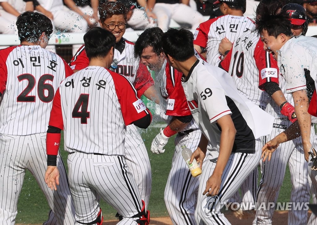 Roberto Ramos of the LG Twins (C) is mobbed by his teammates after blasting a game-winning grand slam against the KT Wiz in the bottom of the ninth inning of a Korea Baseball Organization regular season game at Jamsil Stadium in Seoul on May 24, 2020. (Yonhap)